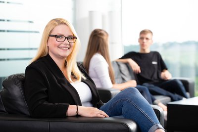 Azubi Portrait mit Team im Hintergrund – Employer Branding
