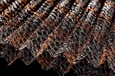 Close-up Produktfotografie von Drahtstrukturen auf dunklem Hintergrund mit starkem Lichtkontrast für visuelle Tiefe.